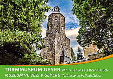 Der Wachtturm Geyer beinhaltet das Turmmuseum und ragt in den blauen Sommerhimmel. Links und rechts wird er von Bäumen umrahmt. Im Wachtturm befindet sich das städtische Heimatmuseum - auch Turmmuseum genannt.